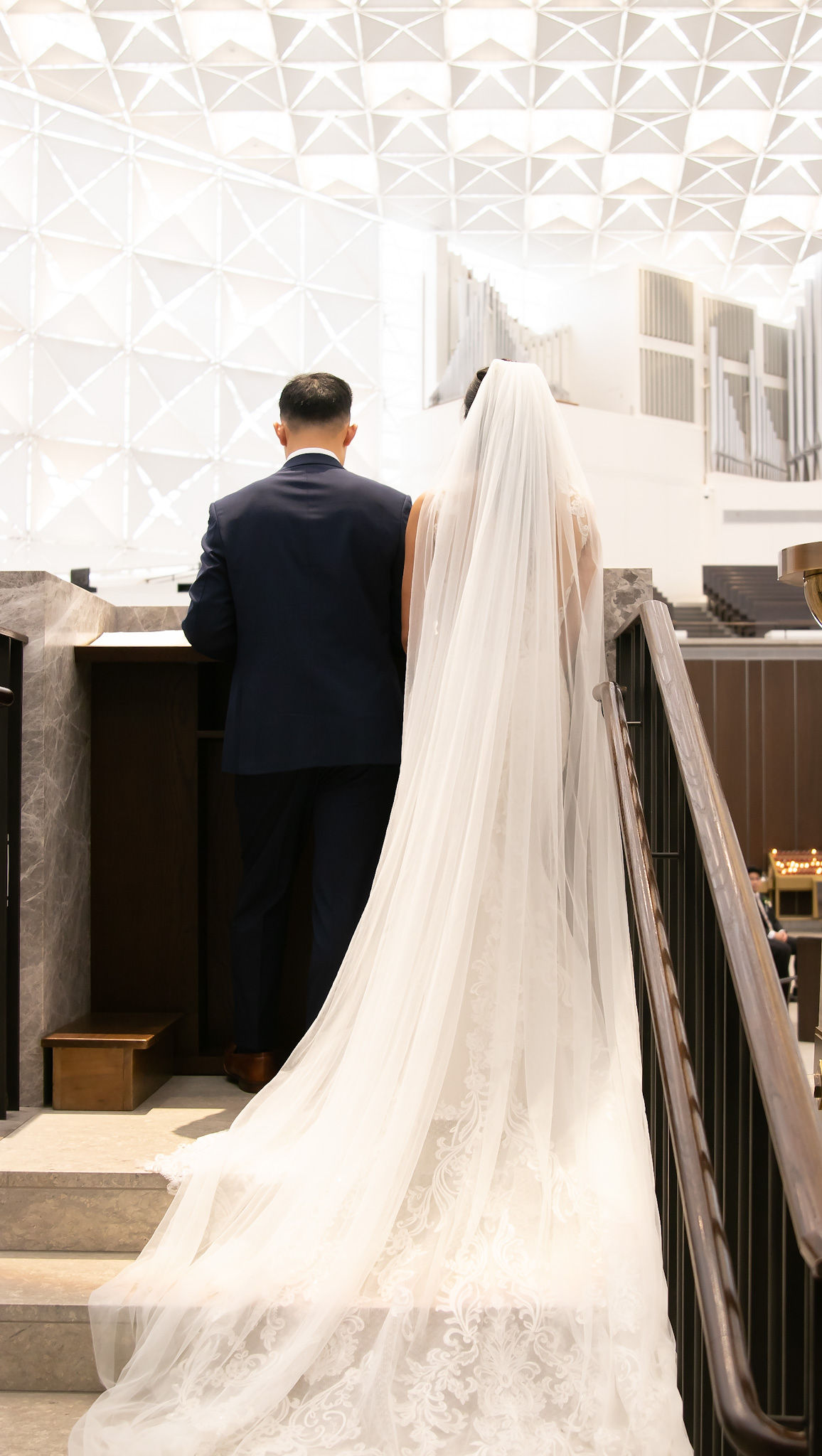 Bride walking with long veil inside church